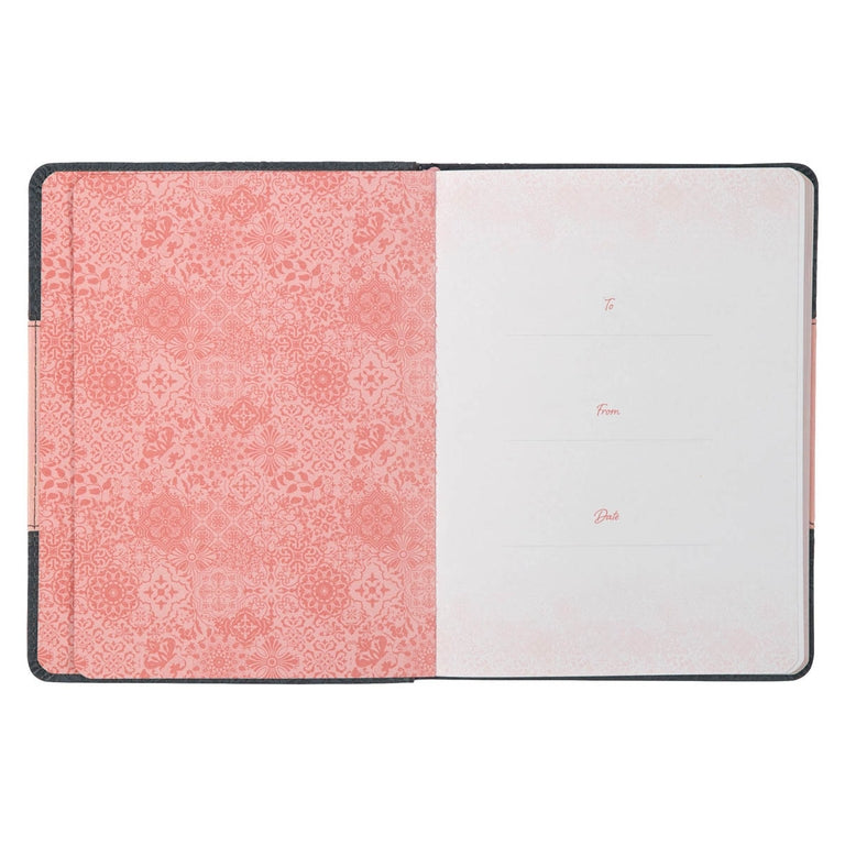 Notebook with pink floral pattern on one page and white on the other, on a white background.
