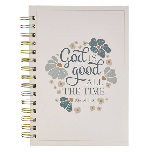 A spiral-bound journal with a cream-colored cover featuring the quote 'God is good ALL THE TIME' in dark blue script and serif fonts, surrounded by blue and gray floral illustrations. The notebook is bound with gold-toned metal spirals on the left side, shown against a plain white background.